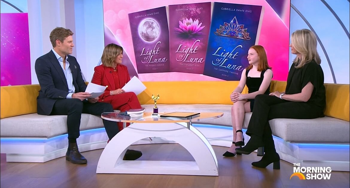 Four people are seated on a studio set for 